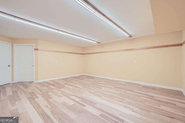 basement with light hardwood / wood-style flooring