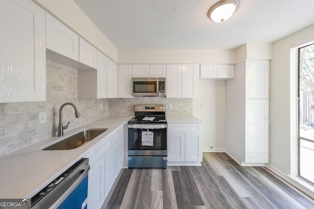 kitchen with white cabinetry, appliances with stainless steel finishes, sink, and a textured ceiling