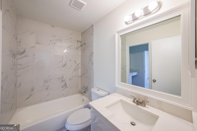 full bathroom featuring vanity, toilet, tiled shower / bath combo, and a textured ceiling