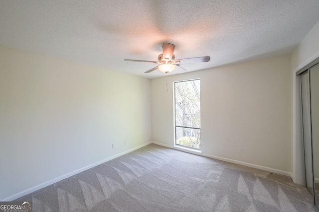 unfurnished bedroom with ceiling fan, carpet, and a textured ceiling