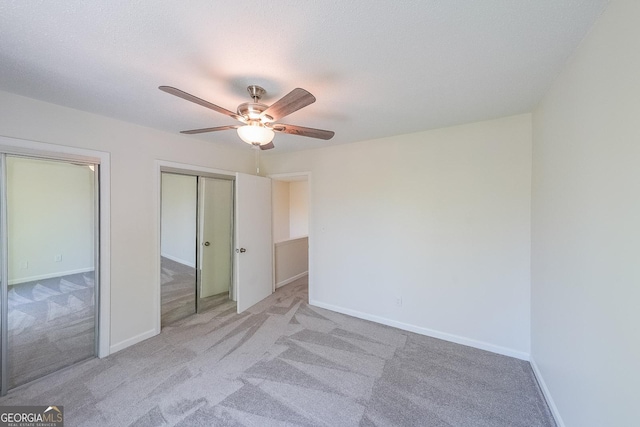 unfurnished bedroom with light colored carpet, a textured ceiling, and ceiling fan