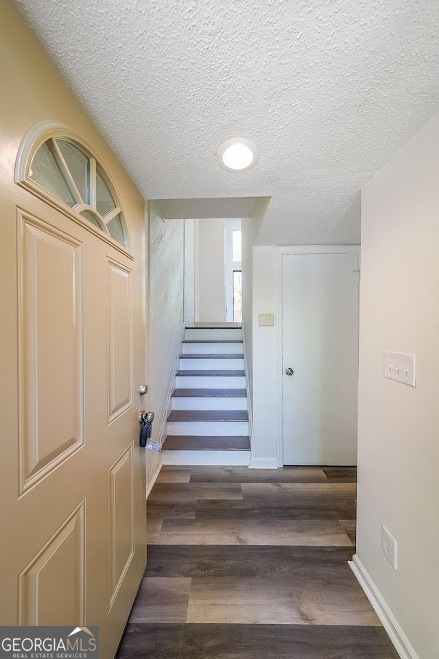 stairway featuring hardwood / wood-style flooring and a textured ceiling