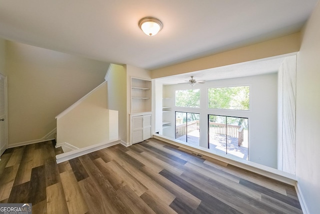 bonus room featuring dark hardwood / wood-style flooring and built in shelves