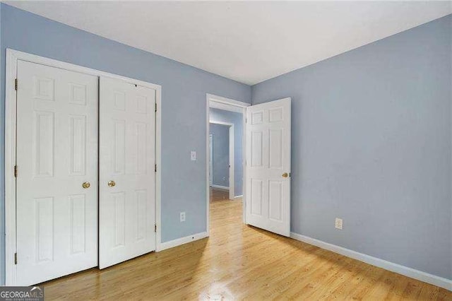 unfurnished bedroom with light hardwood / wood-style flooring and a closet