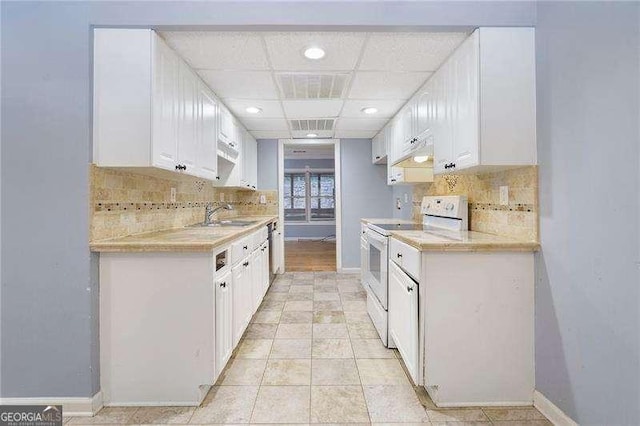 kitchen featuring a drop ceiling, sink, white cabinets, and white range with electric cooktop