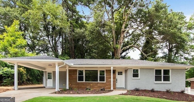 ranch-style house featuring a carport and a front lawn