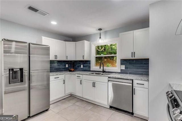 kitchen with sink, hanging light fixtures, white cabinets, and appliances with stainless steel finishes