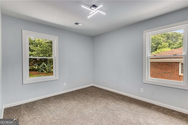 unfurnished room featuring carpet and plenty of natural light