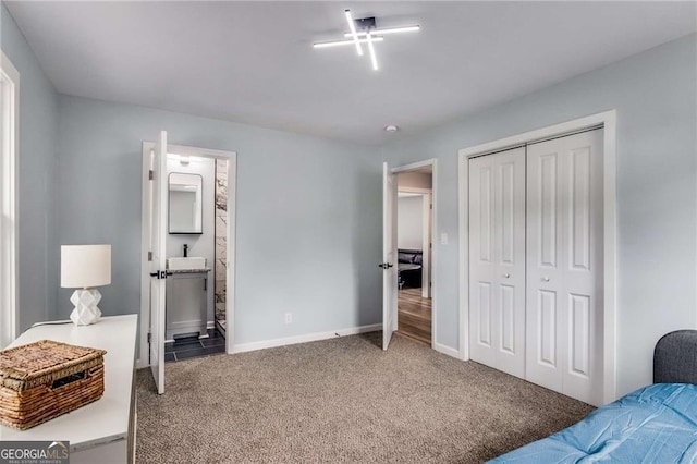 carpeted bedroom with ensuite bathroom and a closet