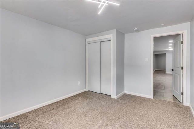 unfurnished bedroom with light colored carpet and a closet