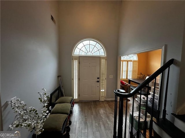 entryway featuring hardwood / wood-style floors and a towering ceiling