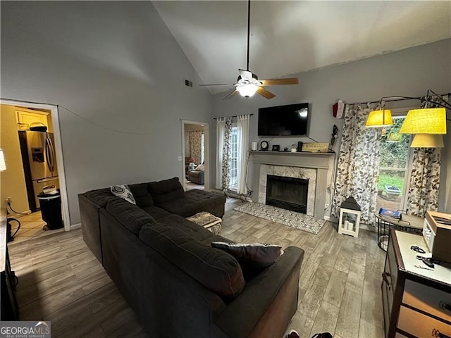 living room featuring hardwood / wood-style floors, high vaulted ceiling, and ceiling fan