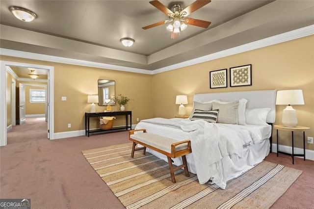 bedroom with a raised ceiling, ceiling fan, and carpet