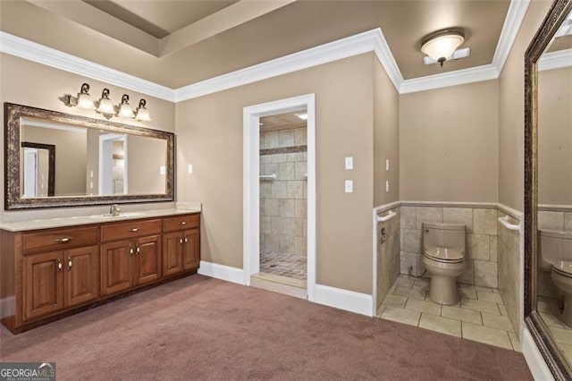 bathroom featuring tile walls, vanity, tiled shower, toilet, and crown molding