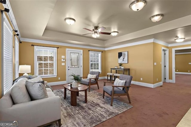 carpeted living room with crown molding, ceiling fan, and a tray ceiling