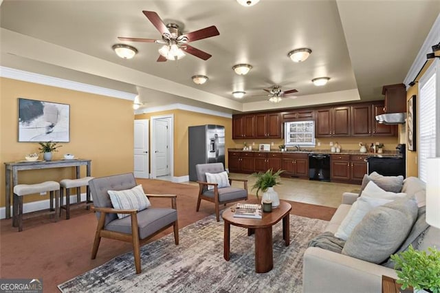 carpeted living room featuring sink, a tray ceiling, and ceiling fan