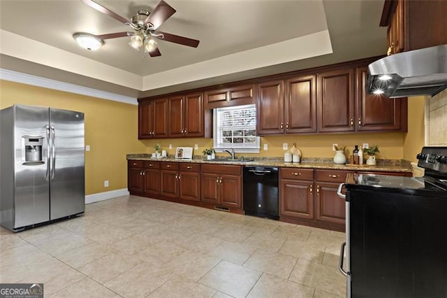 kitchen with extractor fan, sink, appliances with stainless steel finishes, a tray ceiling, and light stone countertops