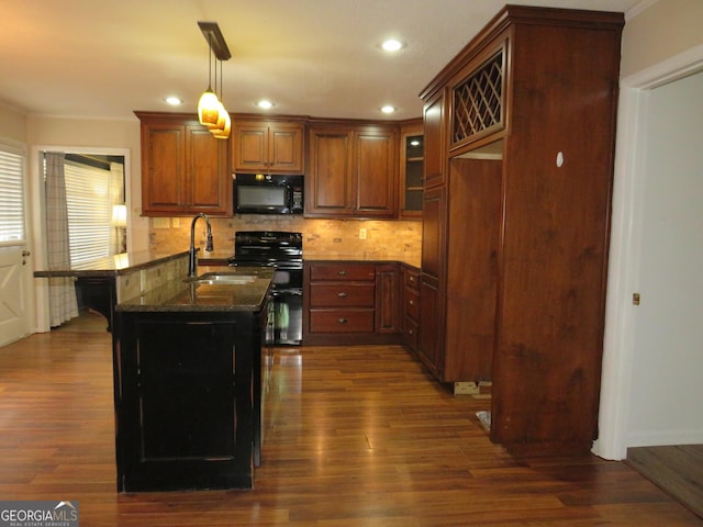 kitchen featuring sink, decorative light fixtures, dark stone countertops, dark hardwood / wood-style floors, and black appliances