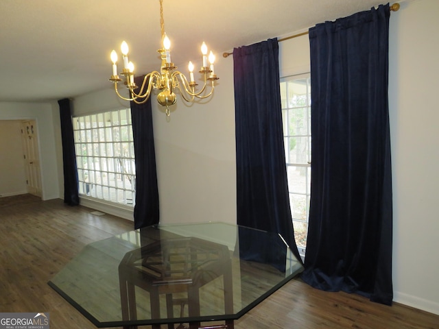 dining area featuring a notable chandelier and dark wood-type flooring