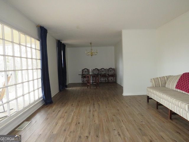 living area with an inviting chandelier and wood-type flooring