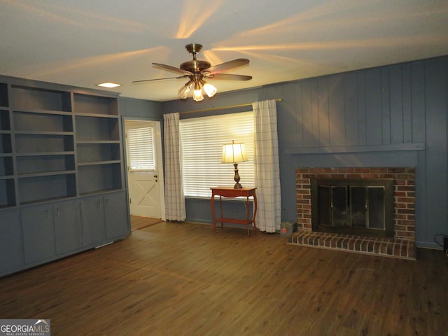 living room featuring ceiling fan, a brick fireplace, dark hardwood / wood-style flooring, and built in shelves