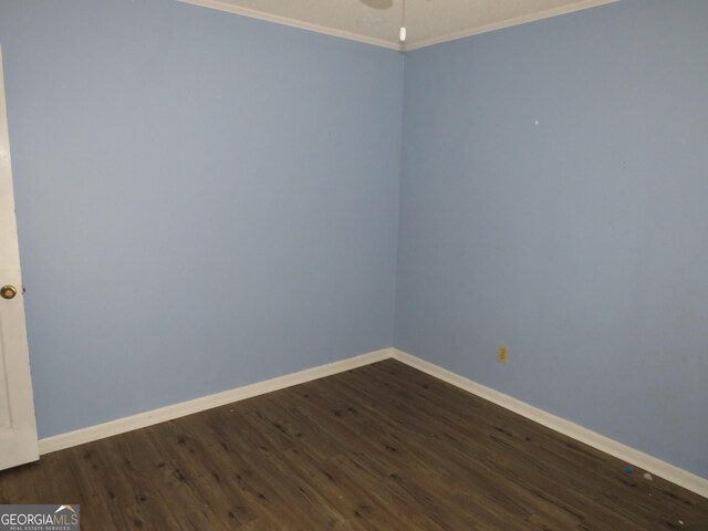 unfurnished room featuring ornamental molding and dark hardwood / wood-style flooring