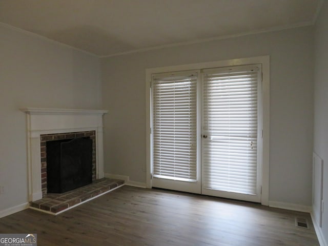 unfurnished living room featuring a brick fireplace, hardwood / wood-style flooring, and ornamental molding