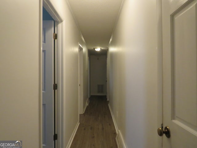 corridor featuring ornamental molding, dark hardwood / wood-style floors, and a textured ceiling