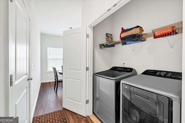 laundry area featuring washing machine and dryer and dark hardwood / wood-style floors