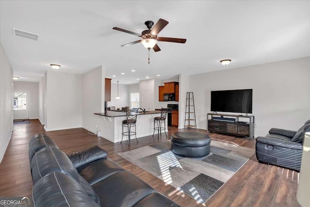 living room with dark hardwood / wood-style floors and ceiling fan