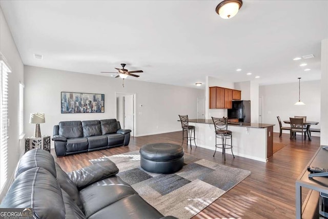 living room featuring dark hardwood / wood-style floors and ceiling fan