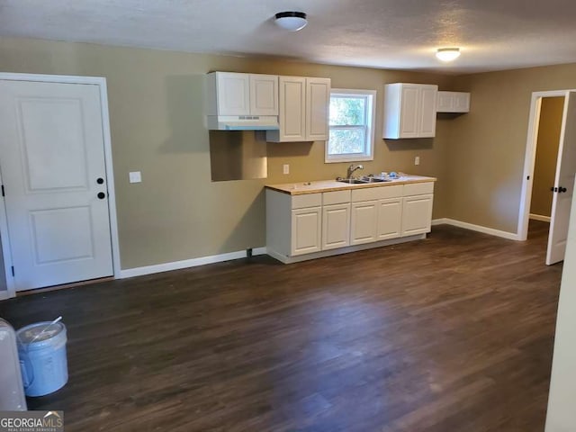 kitchen featuring white cabinetry, sink, a textured ceiling, and dark hardwood / wood-style flooring