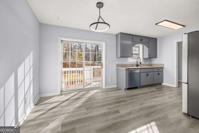 kitchen featuring decorative light fixtures, sink, gray cabinetry, stainless steel appliances, and a textured ceiling