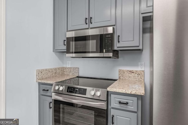 kitchen with stainless steel appliances and gray cabinetry