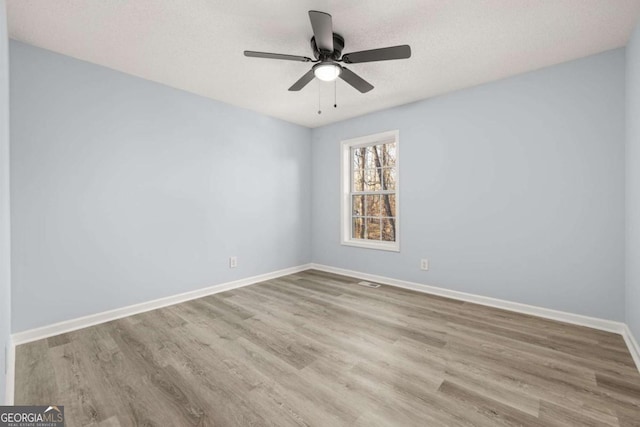 spare room featuring ceiling fan, a textured ceiling, and light wood-type flooring