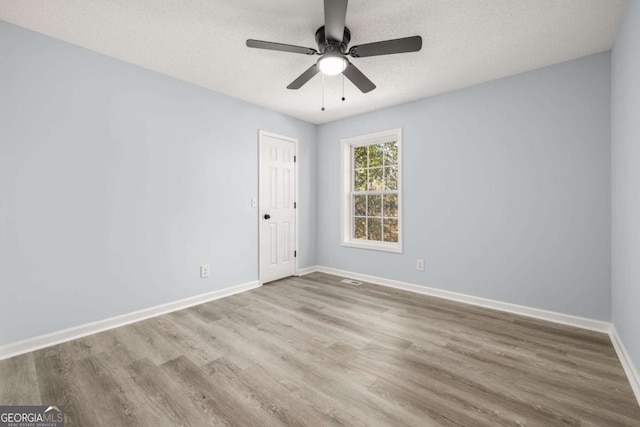 unfurnished room with ceiling fan, a textured ceiling, and light hardwood / wood-style flooring