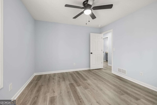 empty room with ceiling fan and light hardwood / wood-style flooring