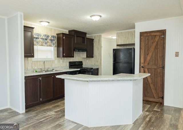 kitchen featuring sink, ornamental molding, black appliances, and a kitchen island