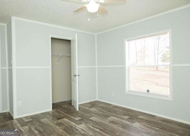 unfurnished bedroom featuring dark hardwood / wood-style flooring, a textured ceiling, ceiling fan, and a closet