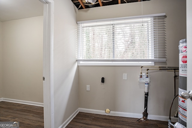 clothes washing area featuring dark hardwood / wood-style flooring and gas water heater