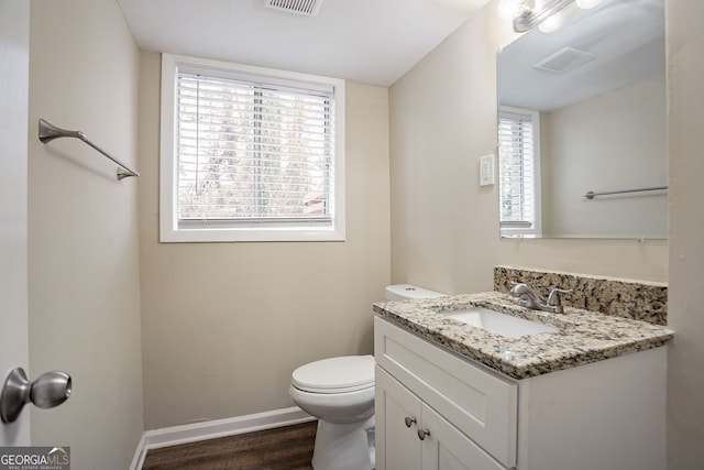 bathroom with vanity, wood-type flooring, a wealth of natural light, and toilet