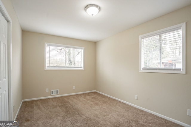 unfurnished bedroom with multiple windows, carpet, and a closet