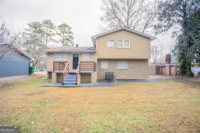 back of property with a patio, central AC unit, and a lawn