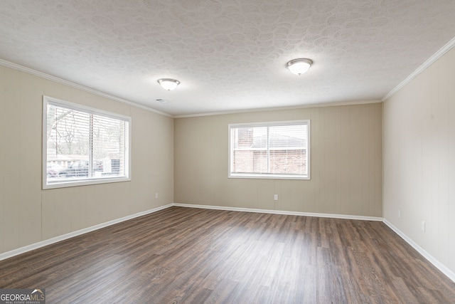 empty room featuring a wealth of natural light, dark wood-type flooring, ornamental molding, and a textured ceiling