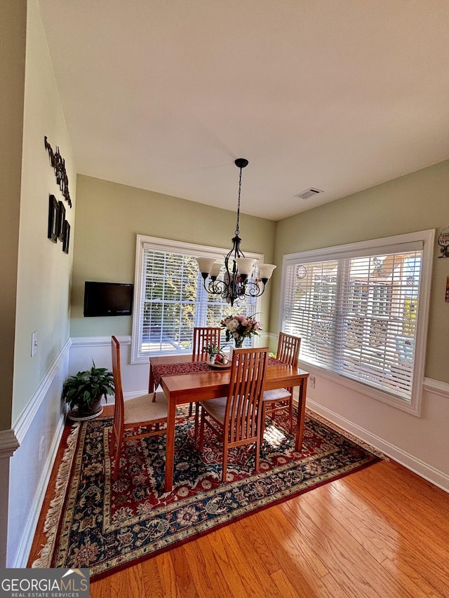 dining room with hardwood / wood-style flooring, a chandelier, and a wealth of natural light