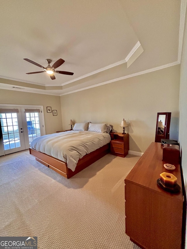 bedroom with carpet, access to exterior, a tray ceiling, crown molding, and french doors