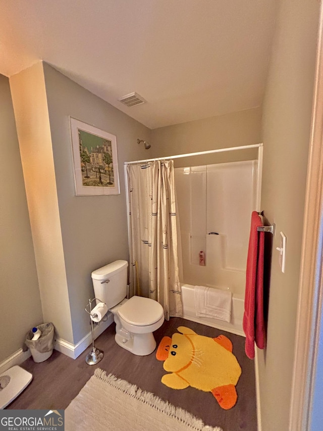 bathroom with shower / tub combo, hardwood / wood-style floors, and toilet