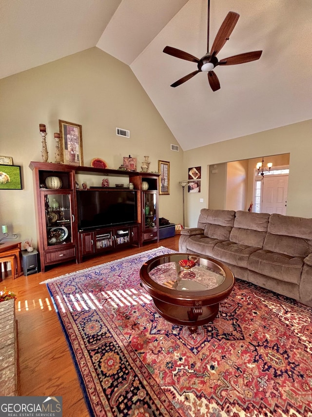 living room featuring ceiling fan with notable chandelier, high vaulted ceiling, and light hardwood / wood-style flooring