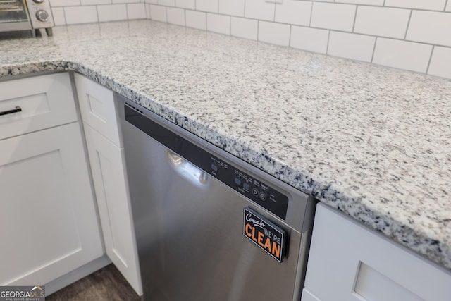 interior details featuring white cabinetry, light stone countertops, and dishwasher