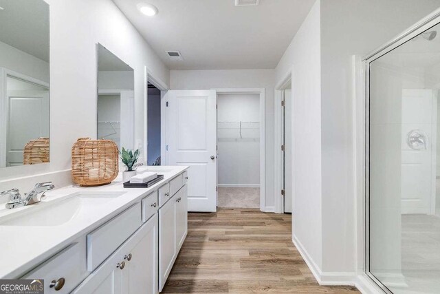 bathroom with vanity, an enclosed shower, and hardwood / wood-style floors